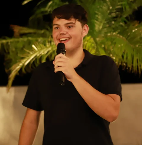 Davi Specia sorrindo ao microfone.