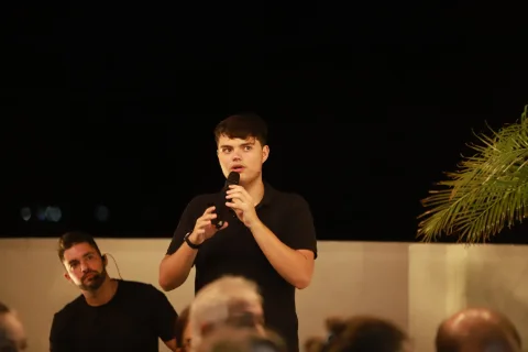 Davi falando ao microfone e gesticulando.